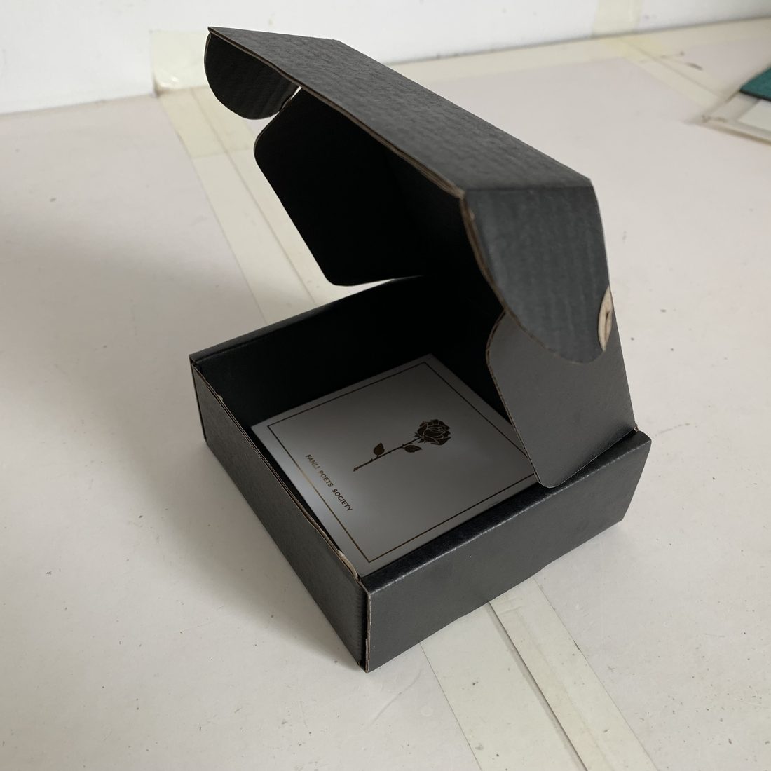 Black corrugated mailer box with magnetic closure, opened to show the flute and interior
